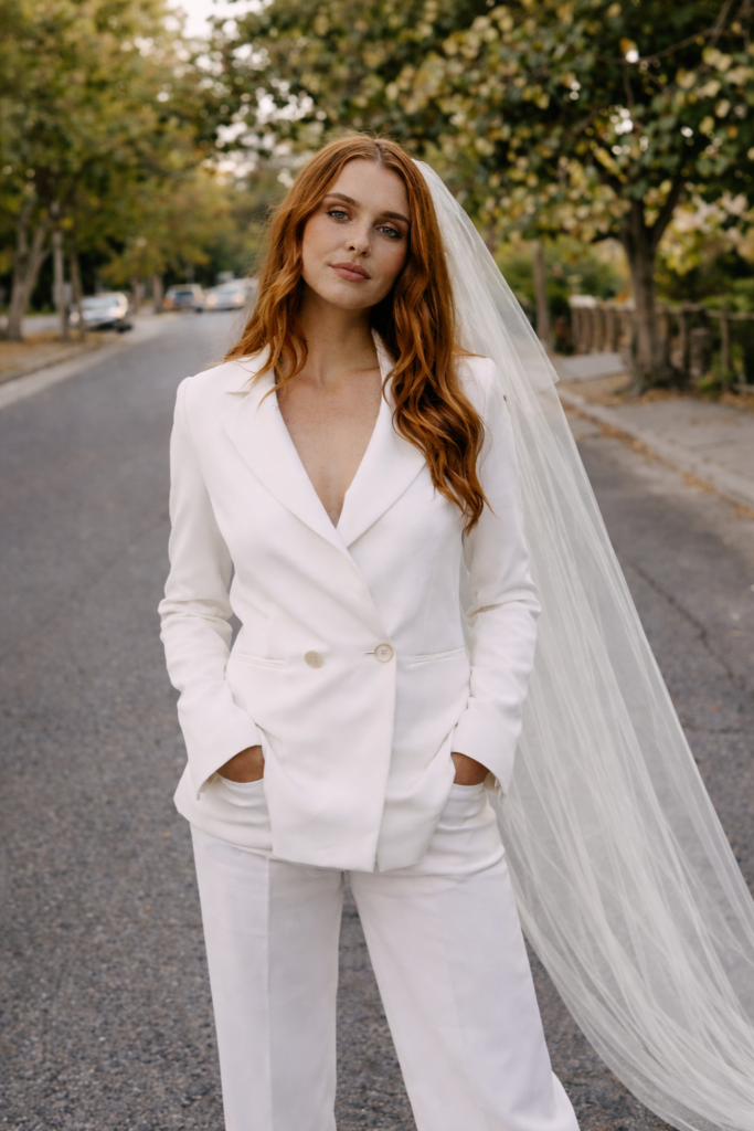 Bride wearing a tailored white bridal suit with a veil, styled for a civil wedding ceremony